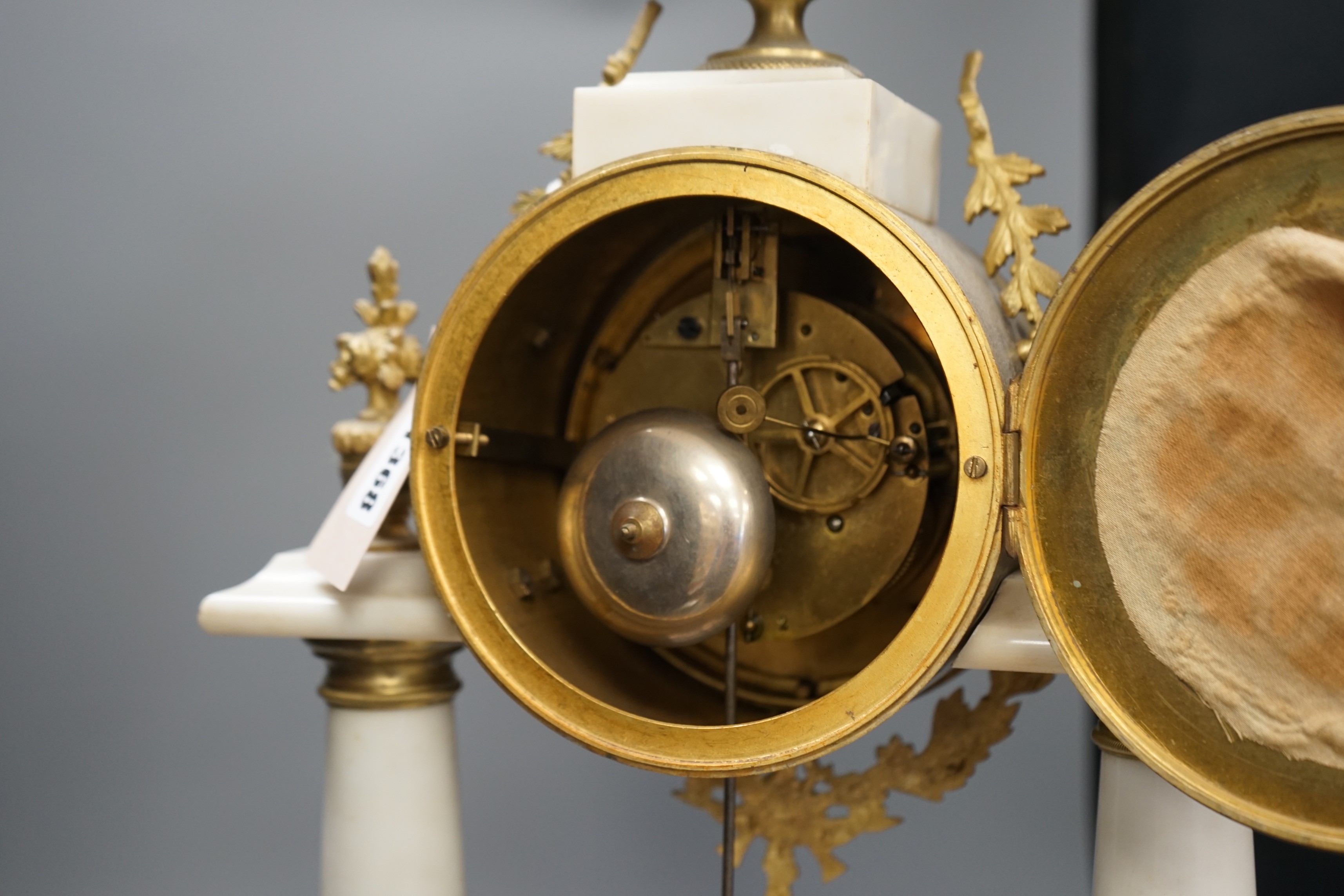 A large French white marble portico clock with ormolu decoration and sunburst pendulum, 59.5cm tall